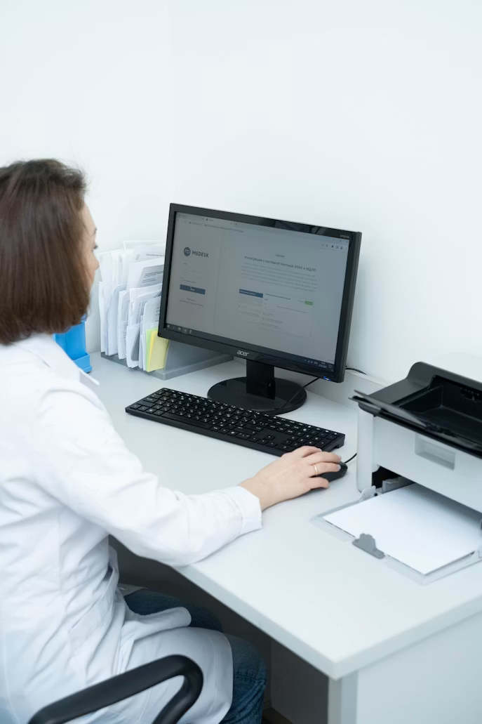 Clinician working at a desk in a healthcare setting