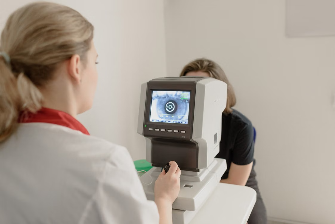 Clinician operating diagnostic equipment during a patient exam
